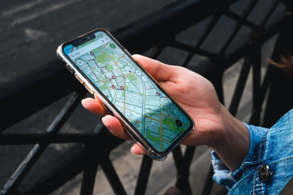 Hand holding a smartphone with a map app, the way you request an Uber in Nice